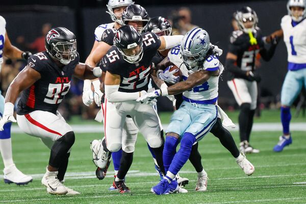 Atlanta Falcons linebacker Kaden Elliss (center) tackles Dallas Cowboys wide receiver CeeDee Lamb (right) during the first half of an NFL football game at Mercedes-Benz Stadium in Atlanta. (Miguel Martinez/AJC 2024)