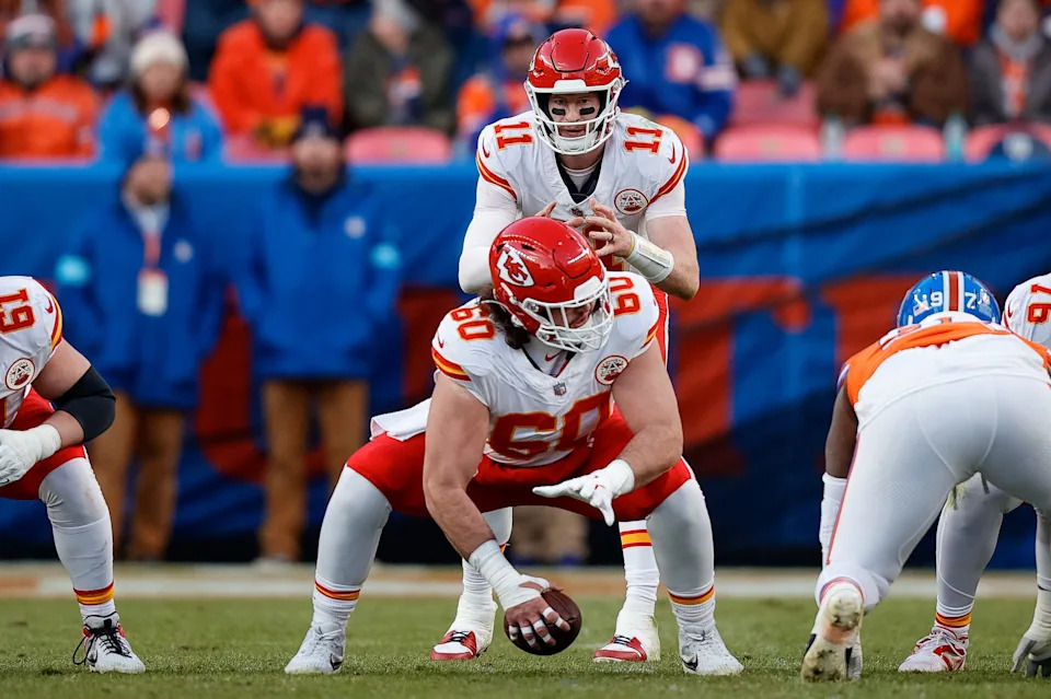 Jan 5, 2025; Denver, Colorado, USA; Kansas City Chiefs quarterback Carson Wentz (11) takes a snap from center Hunter Nourzad (60) in the third quarter against the Denver Broncos at Empower Field at Mile High. Mandatory Credit: Isaiah J. Downing-Imagn Images