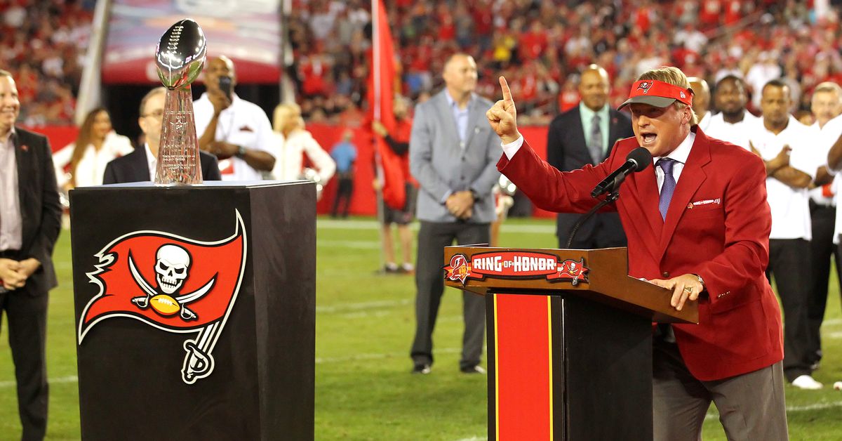 Former Buccaneers HC Jon Gruden receives a 1976 jersey from the team