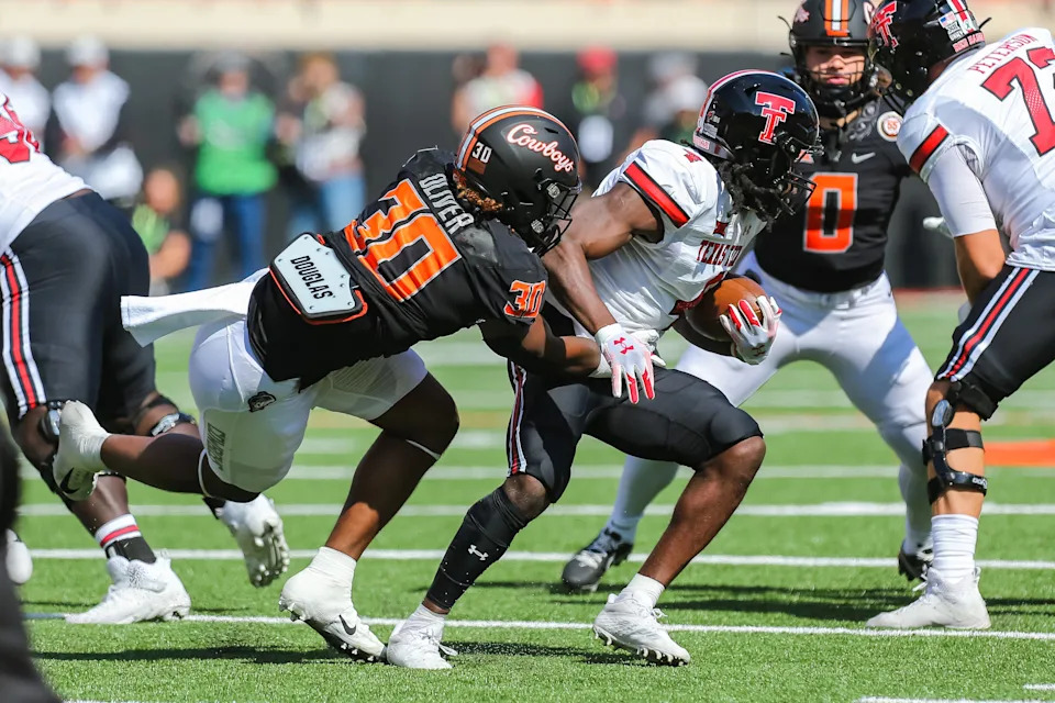 Oct 8, 2022; Stillwater, Oklahoma, USA; Texas Tech Red Raiders running back SaRodorick Thompson (4) runs the ball as Oklahoma State Cowboys defensive end Collin Oliver (30) takes him down in the first quarter at Boone Pickens Stadium. Mandatory Credit: Nathan J Fish/The Oklahoman - USA TODAY NETWORK