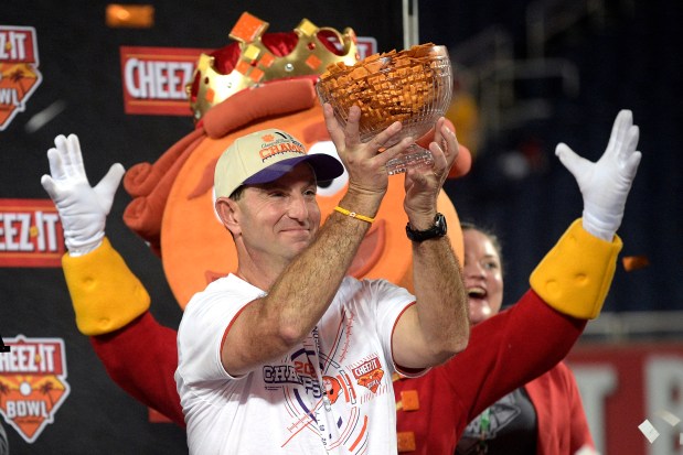 Dabo Swinney holds a trophy full of crackers after winning the 2021 Cheez-It Bowl. (Phelan M. Ebenhack/AP)