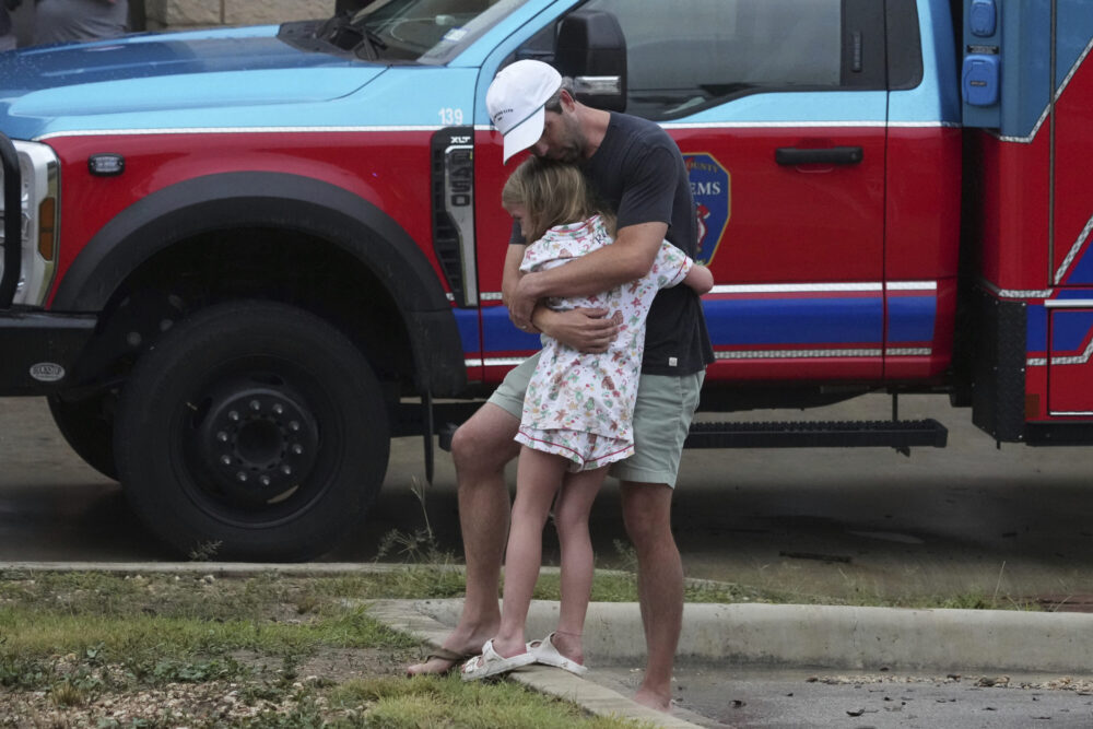 People are reunited at a reunification center after flash flooding hit the area, Friday, July 4, 2025, in Ingram, Texas. (AP Photo/Eric Gay)