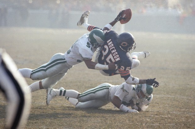 Chicago Bears running back Neal Anderson (35) is tackled by Philadelphia Eagles linebacker Todd Bell, left, and cornerback Eric Allen, right, during the NFC playoff game, Saturday, Jan. 2, 1988 in Chicago. Anderson scored one touchdown and rushed for 54 yards to help the Bears defeat the Eagles 20-12. (AP Photo)