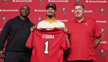 Tampa Bay Bucs first round draft pick Emeka Egbuka holds up a jersey with head coach Todd Bowles (right) and GM Jason Licht during a post draft news conference at One Buc Place in Tampa. (AP Photo/Chris O'Meara)