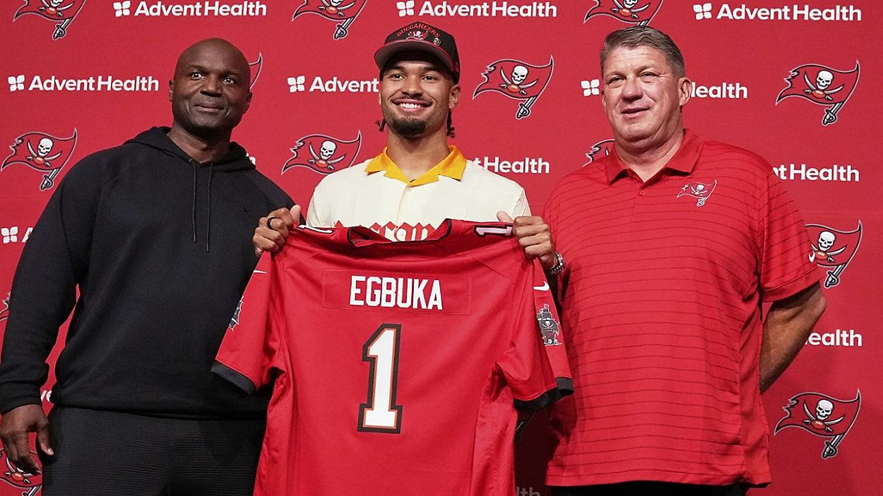 Tampa Bay Bucs first round draft pick Emeka Egbuka holds up a jersey with head coach Todd Bowles (right) and GM Jason Licht during a post draft news conference at One Buc Place in Tampa. (AP Photo/Chris O'Meara)