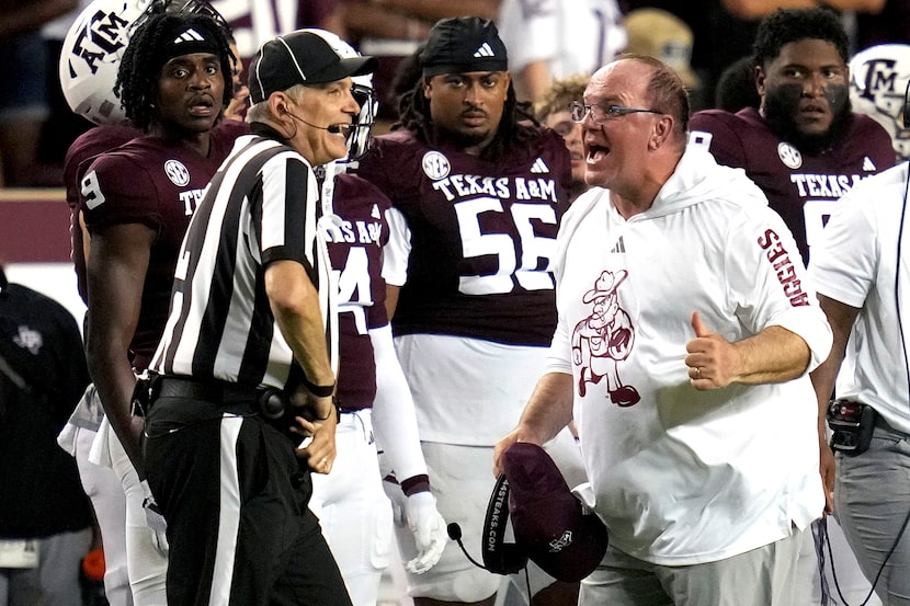 Texas A&M head coach Mike Elko, front right, argues a non call with an official, front left,...