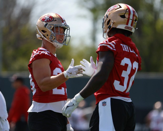 San Francisco 49ers' Christian McCaffrey (23) high-fives San Francisco 49ers' Patrick Taylor Jr. (32) during practice at the 49ers training camp at the practice facility at Levi's Stadium in Santa Clara, Calif., on Wednesday, July 23, 2025. (Nhat V. Meyer/Bay Area News Group)