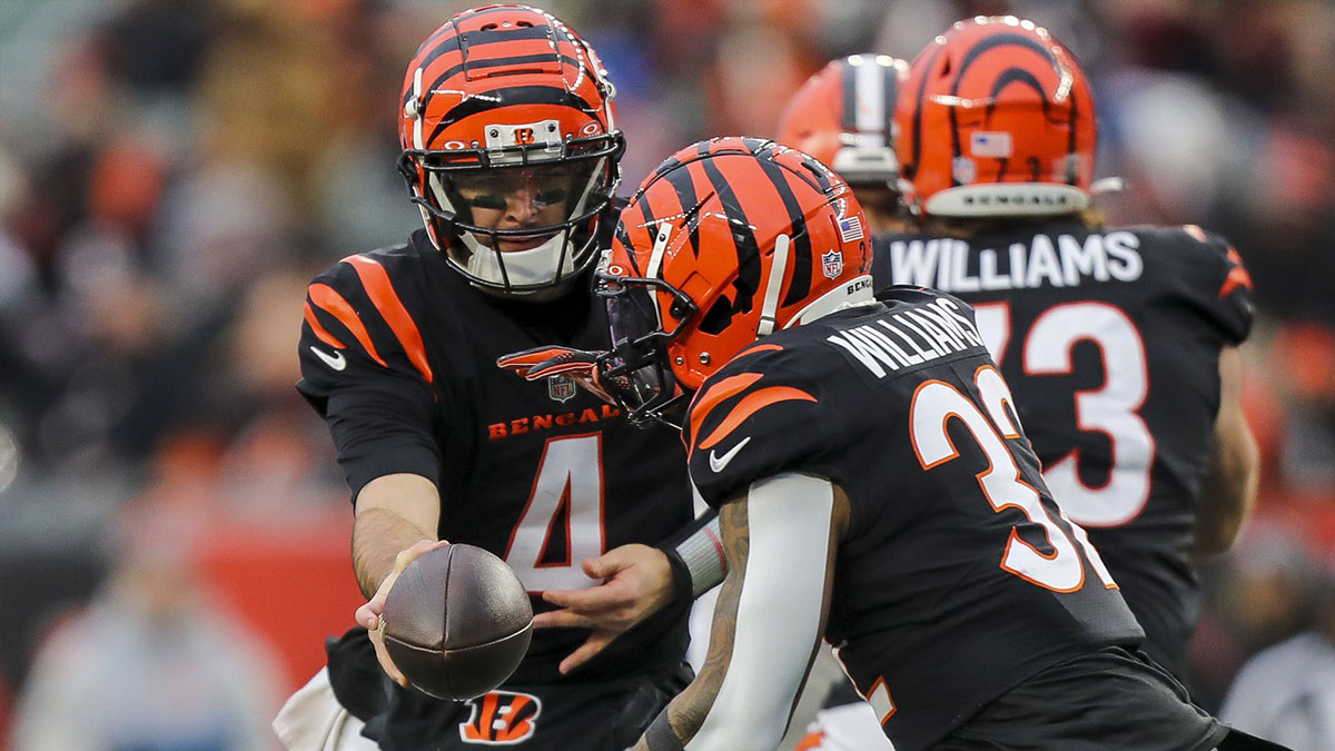 Cincinnati Bengals quarterback AJ McCarron (4) hands the ball off to running back Trayveon Williams (32) in the second half against the Cleveland Browns at Paycor Stadium.