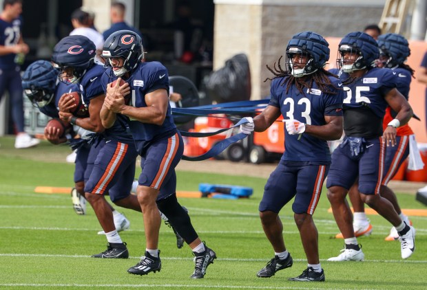 Chicago Bears running backs including Travis Homer (21) and Ian Wheeler (33) in the foreground, run through drills during training camp on July 28, 2025, in Lake Forest. (Stacey Wescott/Chicago Tribune)