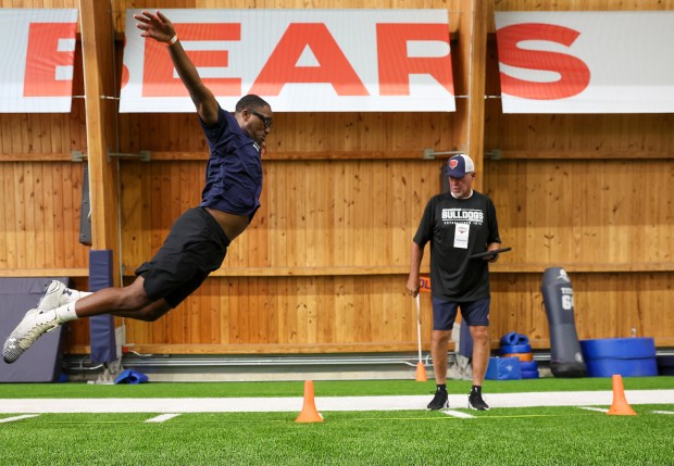 Julian Turner, left, of the U.S. Navy, wins the broad...