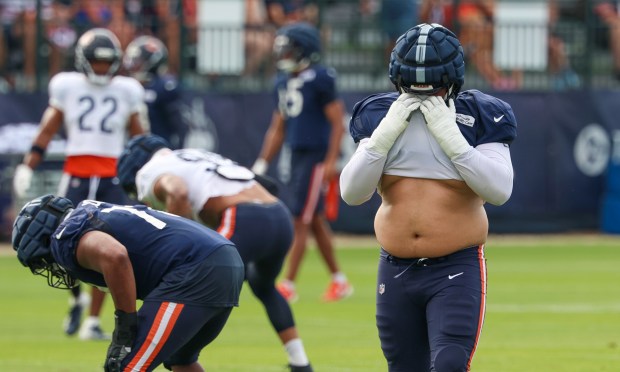 Chicago Bears offensive tackle Darnell Wright (58) wipes off his face with his shirt during a very humid and hot training camp on July 29, 2025, in Lake Forest.  (Stacey Wescott/Chicago Tribune)