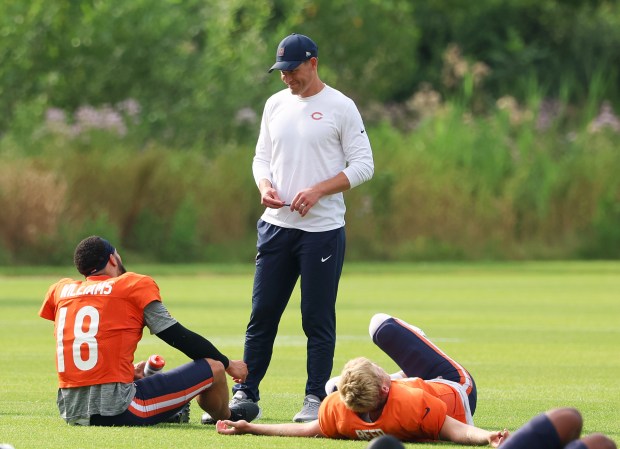 Chicago Bears head coach Ben Johnson stops to talk to quarterbacks Caleb Williams (18) and Austin Reed (16) during training camp at Halas Hall on July 29, 2025, in Lake Forest.  (Stacey Wescott/Chicago Tribune)
