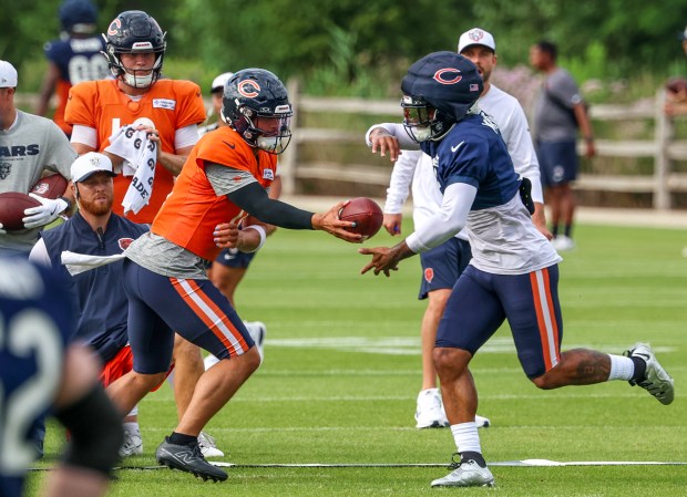 Chicago Bears quarterback Caleb Williams (18) hands off the ball to wide receiver DJ Moore (2) during training camp at Halas Hall on July 29, 2025, in Lake Forest.  (Stacey Wescott/Chicago Tribune)