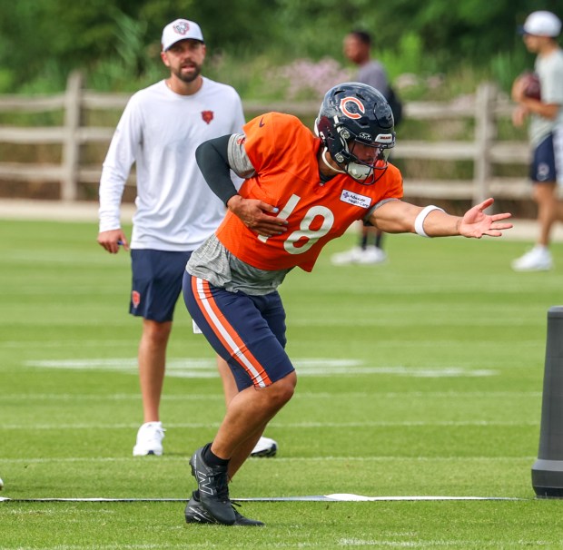 Chicago Bears quarterback Caleb Williams (18) continues to the play after handing off the ball to wide receiver DJ Moore (2) during training camp at Halas Hall on July 29, 2025, in Lake Forest.  (Stacey Wescott/Chicago Tribune)