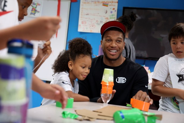 Bears receiver DJ Moore and daughter Arielle, 5, build a water-propelled rocket with other youths at the Bartlett J. McCartin Boys & Girls Club on Friday, July 18, 2025. The Boys & Girls Clubs of Chicago teamed up with Moore's Moore2Life Foundation to host a Back to School bash in celebration of local youth. (Antonio Perez/Chicago Tribune)