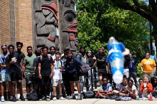 Youths look on as a water-propelled rocket heads downward after being launched outside the Bartlett J. McCartin Boys & Girls Club on Friday, July 18, 2025. The Boys & Girls Clubs of Chicago teamed up with Moore's Moore2Life Foundation to host a Back to School bash in celebration of local youth. (Antonio Perez/Chicago Tribune)