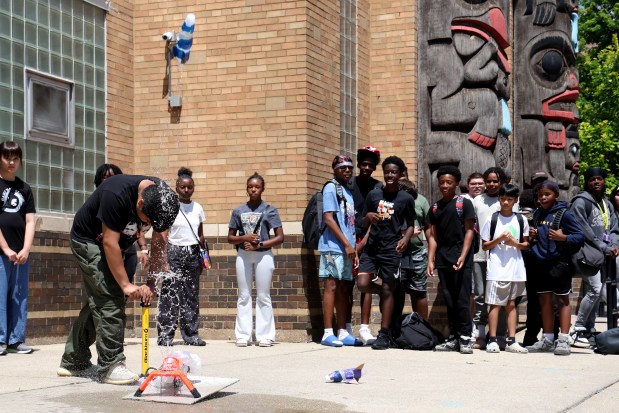 Staff member Julian Ascencio pumps and launches a water-propelled rocket as youths look on outside the Chicago Boys and Girls Clubs of Chicago's Bartlett J. McCartin Club on Friday, July 18, 2025. The Boys and Girls Clubs of Chicago teamed up with Moore's Moore2Life Foundation to host a Back to School bash in celebration of local youth. (Antonio Perez/Chicago Tribune)