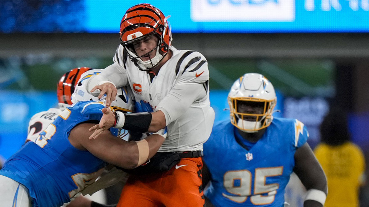 Cincinnati Bengals quarterback Joe Burrow (9) is hit hard as he throws by Los Angeles Chargers linebacker Tuli Tuipulotu (45) in the fourth quarter at SoFi Stadium.