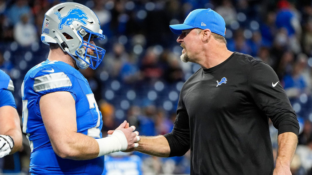 Detroit Lions head coach Dan Campbell shakes hands with center Frank Ragnow (77) warm up before the game between Detroit Lions and Chicago Bears at Ford Field in Detroit on Thursday, Nov. 28, 2024.