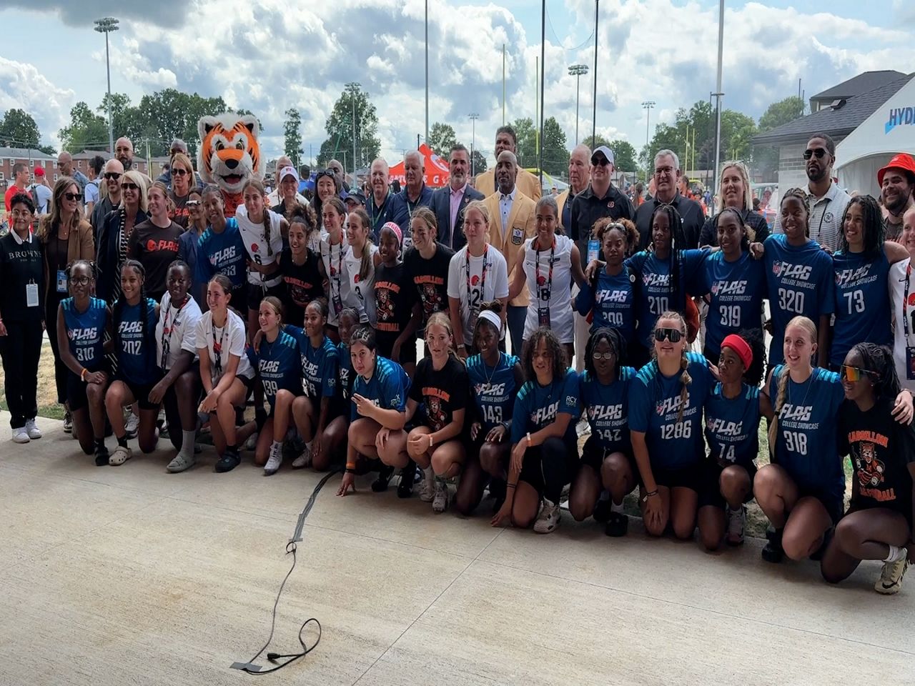 Representatives from the Cincinnati Bengals, Cleveland Browns, the Pro Football Hall of Fame, and the OHSAA celebrate with players as Ohio sponsors girls flag football as a varsity sport.