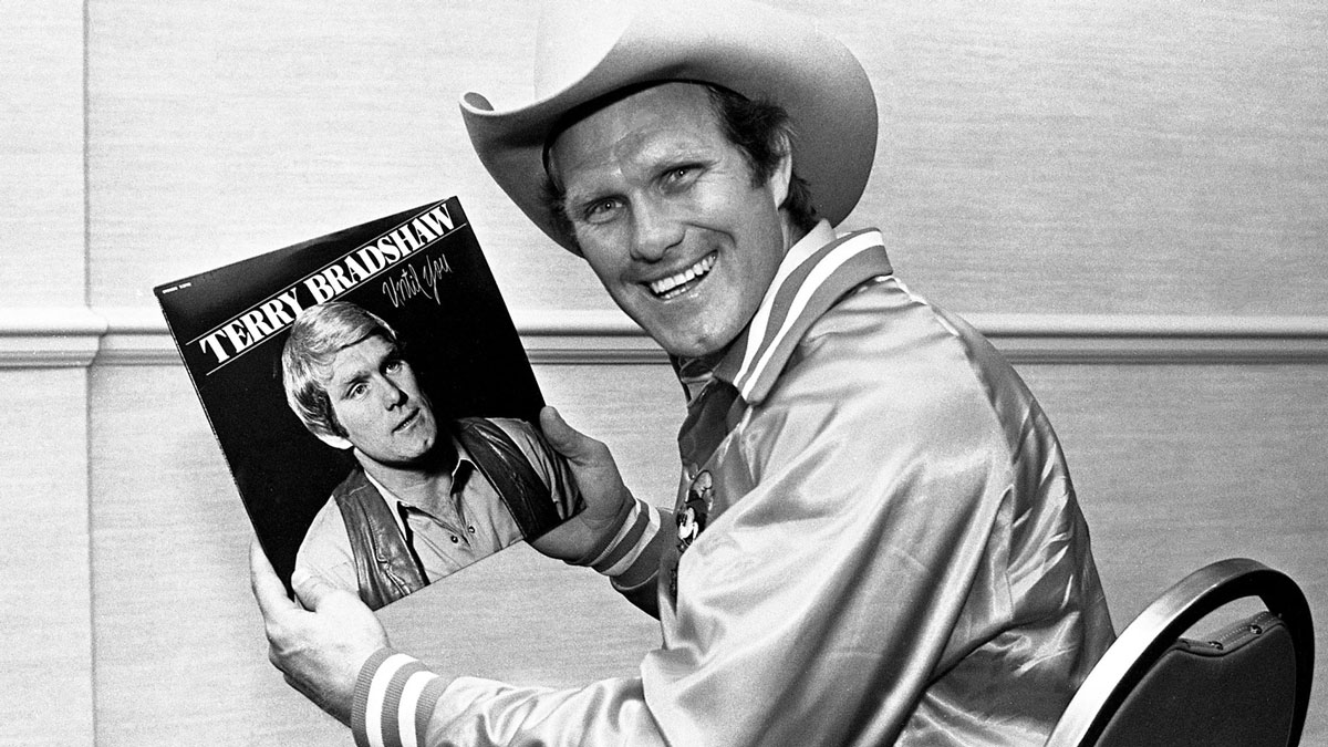 Pittsburgh Steelers star quarterback Terry Bradshaw shows off his new album, \"Until You,\" in between signing copies for fans at Opryland Hotel on March 25, 1980. The album, on the Benson label, was produced here and represents Bradshaw's first venture into gospel music recording. 80then03 057