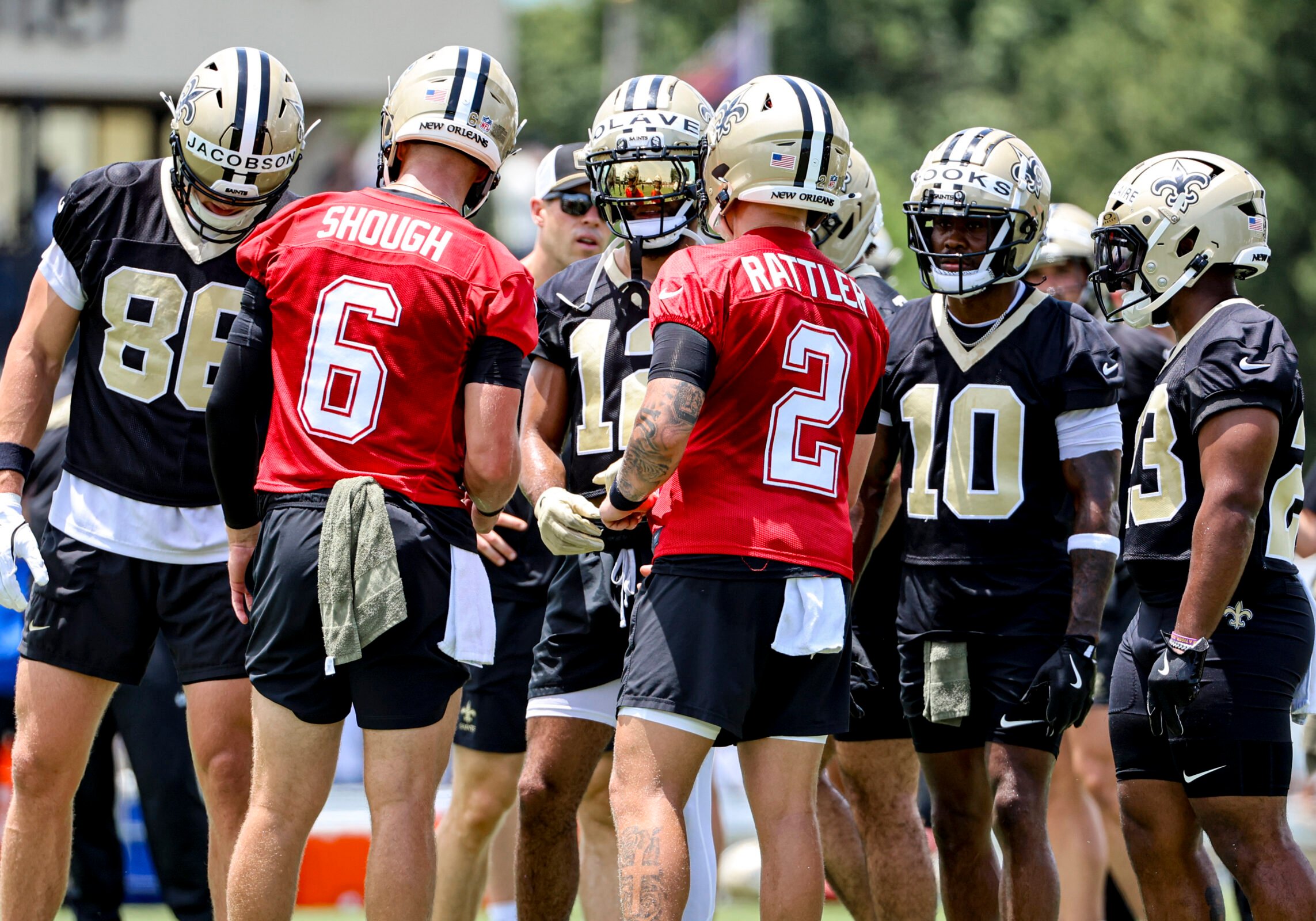 Tyler Shough and Spencer Rattler talk to teammates at New Orleans Saints Mandatory Minicamp