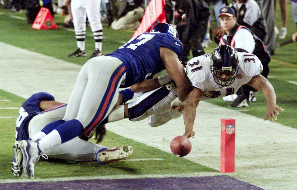 TAMPA, UNITED STATES:  Baltimore Ravens' running back Jamal Lewis (31) stretches the ball over the goal line for a touchdown as two New York Giant defenders attempt to stop him during second half action in Super Bowl XXXV 28 January, 2001 at Raymond James Stadium in Tampa, Florida. The Ravens won the game 34-7.   AFP PHOTO/Don EMMERT (Photo credit should read DON EMMERT/AFP via Getty Images)