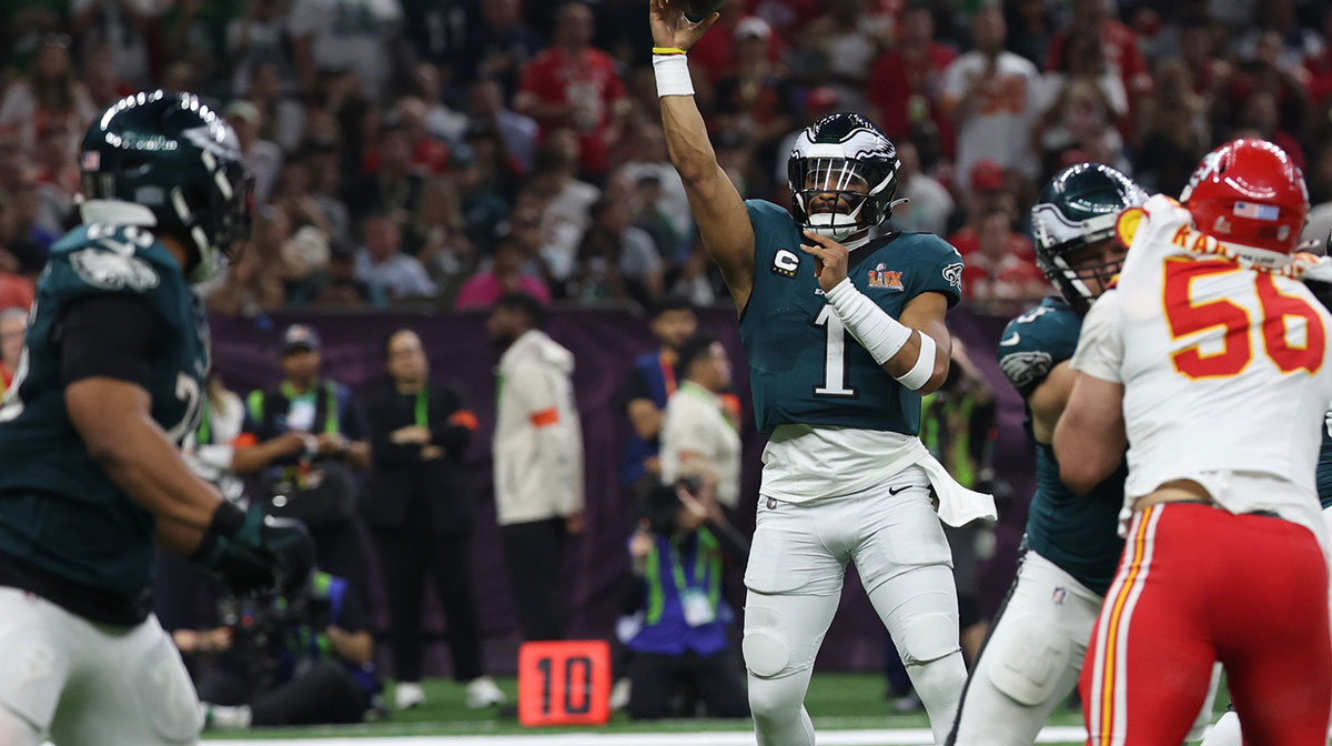 Philadelphia Eagles quarterback Jalen Hurts (1) passes the ball to Eagles running back Saquon Barkley (26) against the Kansas City Chiefs during Super Bowl LIX at Caesars Superdome. 