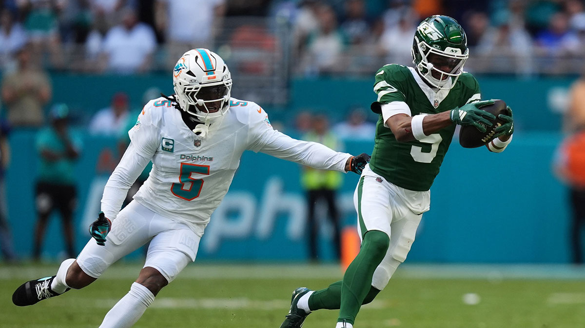 New York Jets wide receiver Garrett Wilson (5) runs with the ball away from Miami Dolphins cornerback Jalen Ramsey (5) during the first half at Hard Rock Stadium.