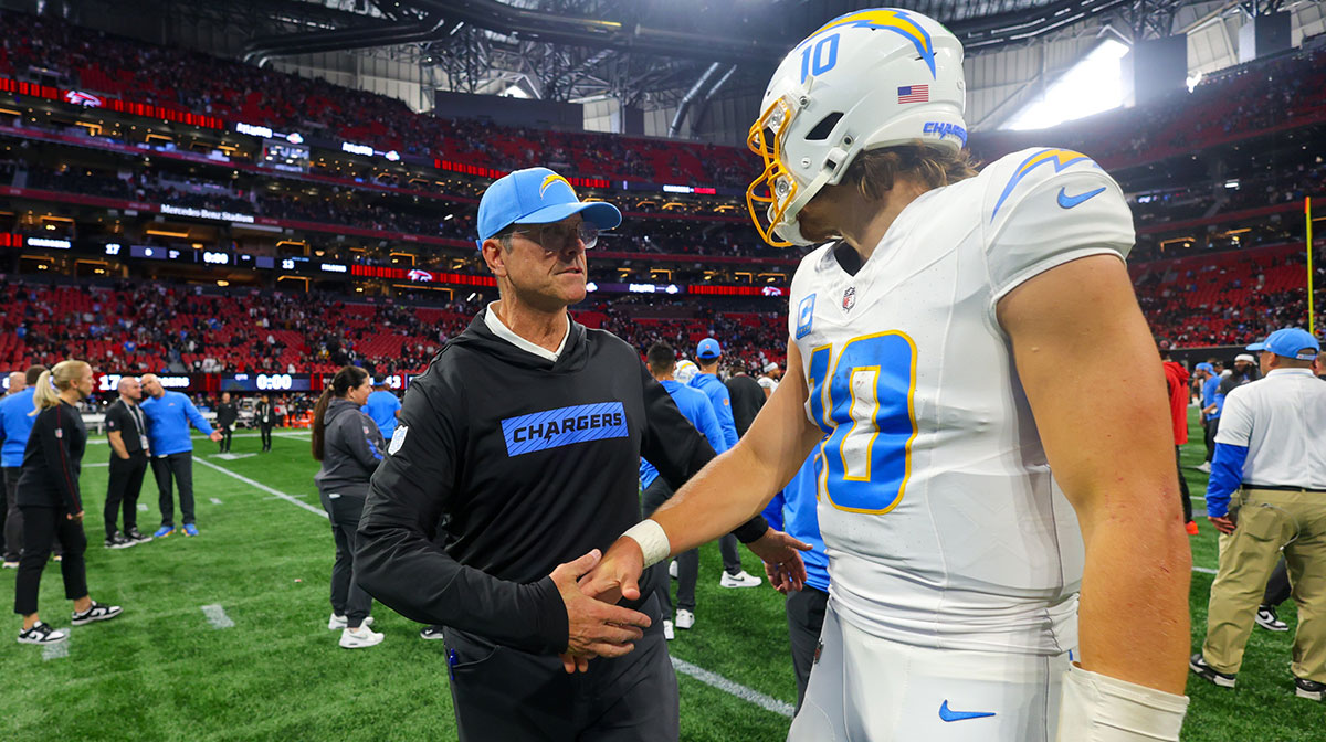 Los Angeles Chargers head coach Jim Harbaugh talks to quarterback Justin Herbert (10) after a victory over the Atlanta Falcons at Mercedes-Benz Stadium.
