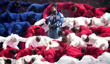 Kendrick Lamar stands amid Black dancers in red, white and blue tracksuits forming an American flag during his halftime performance at Super Bowl LIX.