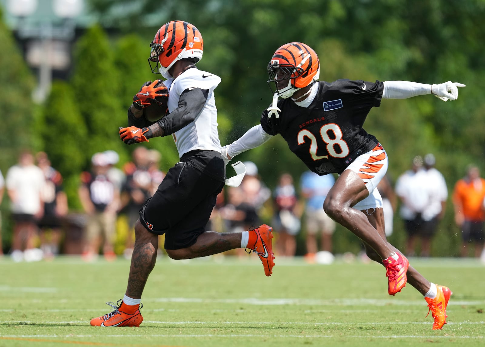 Cincinnati Bengals wide receiver Ja'Marr Chase, center, makes a catch against Josh Newton (28) during practice at the team's NFL football training camp, Sunday, July 27, 2025, in Cincinnati. (AP Photo/Jeff Dean)