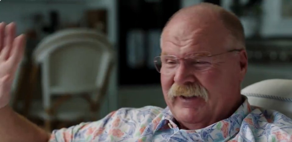 Man with glasses and mustache gestures while speaking.