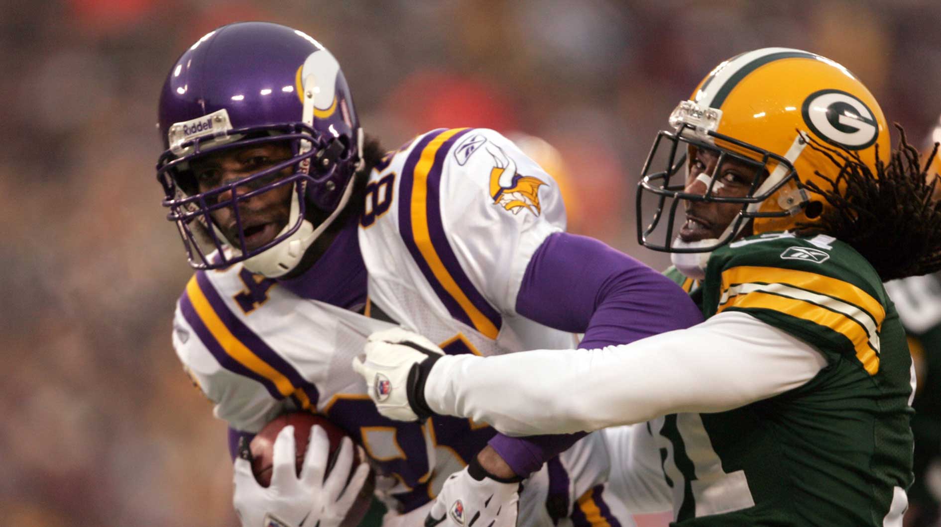 The Minnesota Vikings (84) Randy Moss catches a 7-yard Daunte Culpepper (not pictured) pass as Green Bay defensive back Al Harris defends in the first quarter of the 2004 NFC Wild Card Playoff Game at Lambeau Field.