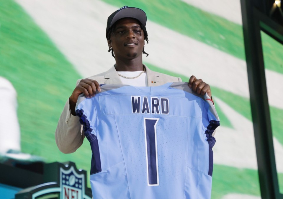 Cam Ward holding a Tennessee Titans jersey at the NFL draft.