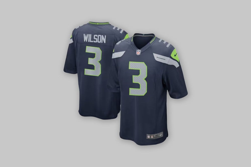 Front and back views of the Russell Wilson Seattle Seahawks Nike Youth Team Color Game Jersey in blue against a light gray background.