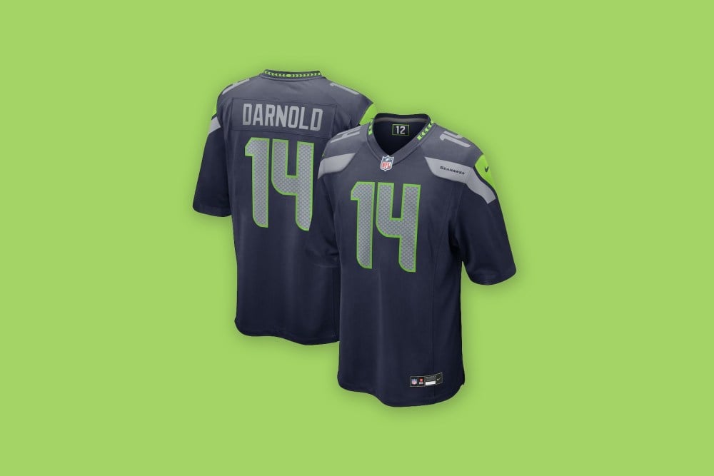 Front and back views of the Sam Darnold Seattle Seahawks Nike Team Game Jersey in blue against a neon green background.