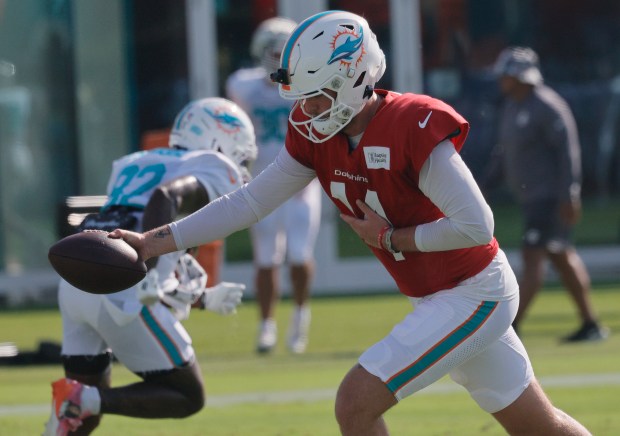 Miami Dolphins quarterback Quinn Ewers (14) drops back during practice...