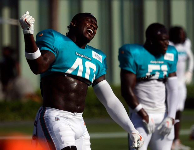 Miami Dolphins linebacker Willie Gay (40) sings along with music...