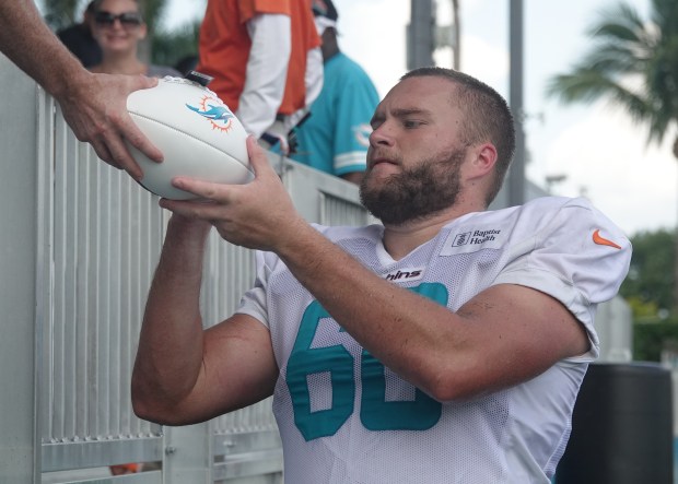Miami Dolphins center Andrew Meyer (60) signs for fans during...