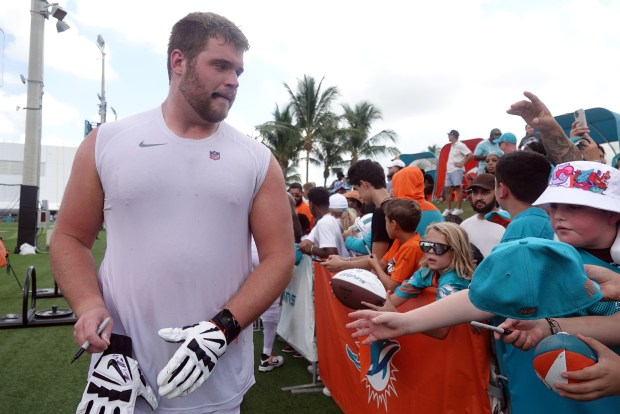 Miami Dolphins guard Josh Priebe (68) signs for fans during...
