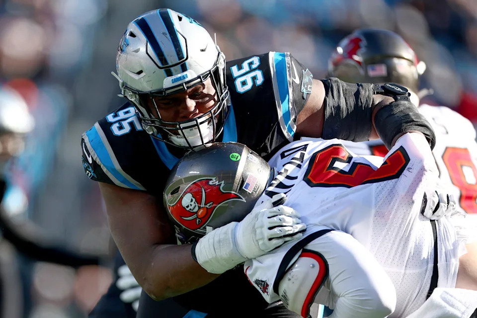 CHARLOTTE, NORTH CAROLINA - JANUARY 07: Derrick Brown #95 of the Carolina Panthers tackles Baker Mayfield #6 of the Tampa Bay Buccaneers during the third quarter at Bank of America Stadium on January 07, 2024 in Charlotte, North Carolina. (Photo by Jared C. Tilton/Getty Images)