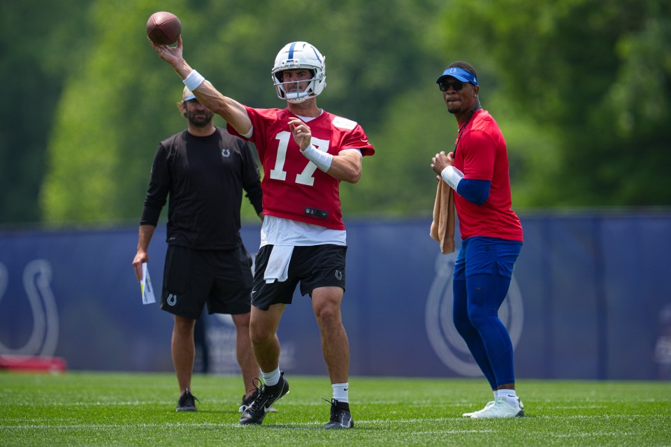 Indianapolis Colts quarterback Daniel Jones throwing a football during practice, with Anthony Richardson Sr. watching.
