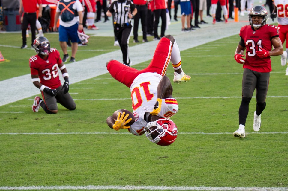 Football player doing a backflip into the end zone for a touchdown.