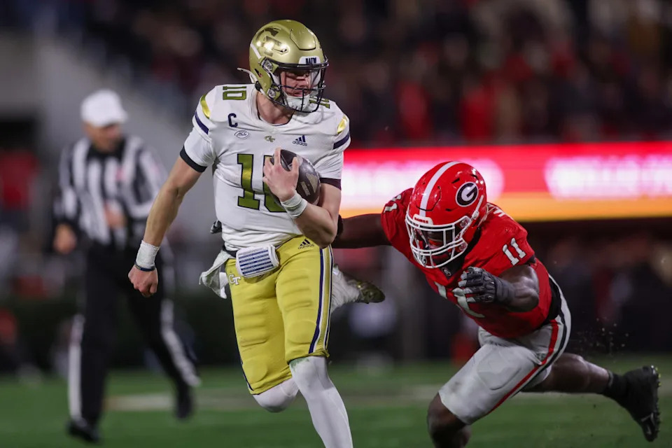 Georgia Tech Yellow Jackets quarterback Haynes King (10) runs past Georgia Bulldogs linebacker Jalon Walker (11).Brett Davis-Imagn Images