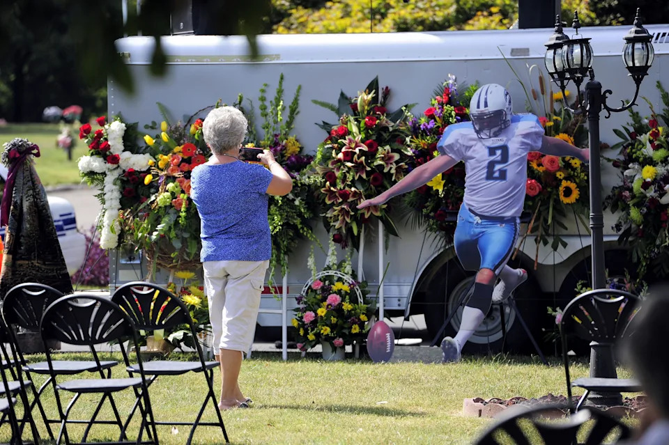 Melissa Sanders of Nashville takes picture of the memorial for former Tennessee Titans kicker Rob Bironas at his funeral at the Woodlawn Roesch-Patton funeral home in Nashville on Sept. 25, 2014. Bironas, 36, died on Sept. 20 in a single-vehicle crash.