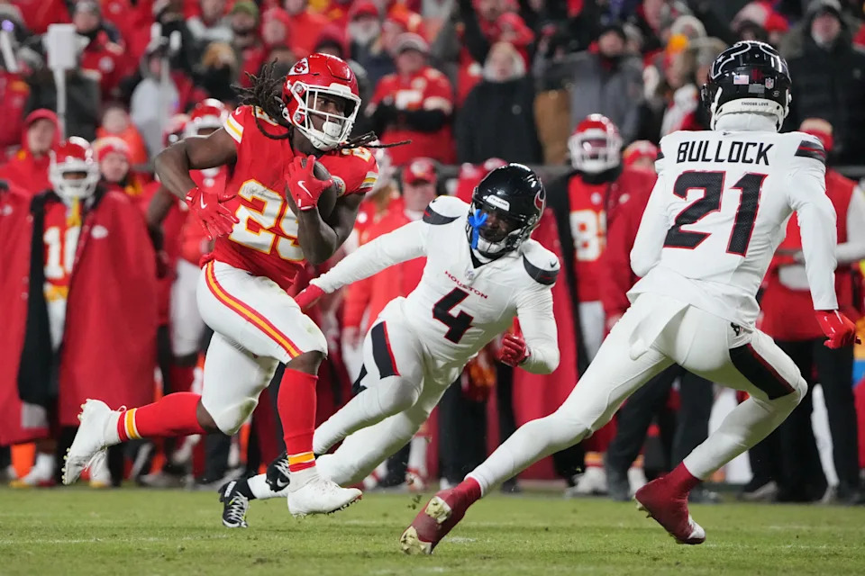 Jan 18, 2025; Kansas City, Missouri, USA; Kansas City Chiefs running back Kareem Hunt (29) runs the ball against Houston Texans cornerback Kamari Lassiter (4) and safety Calen Bullock (21) during the fourth quarter of a 2025 AFC divisional round game at GEHA Field at Arrowhead Stadium. Mandatory Credit: Denny Medley-Imagn Images