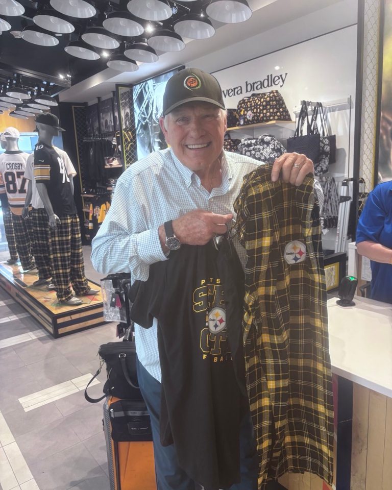 Man holding Pittsburgh Steelers pajamas and t-shirt.