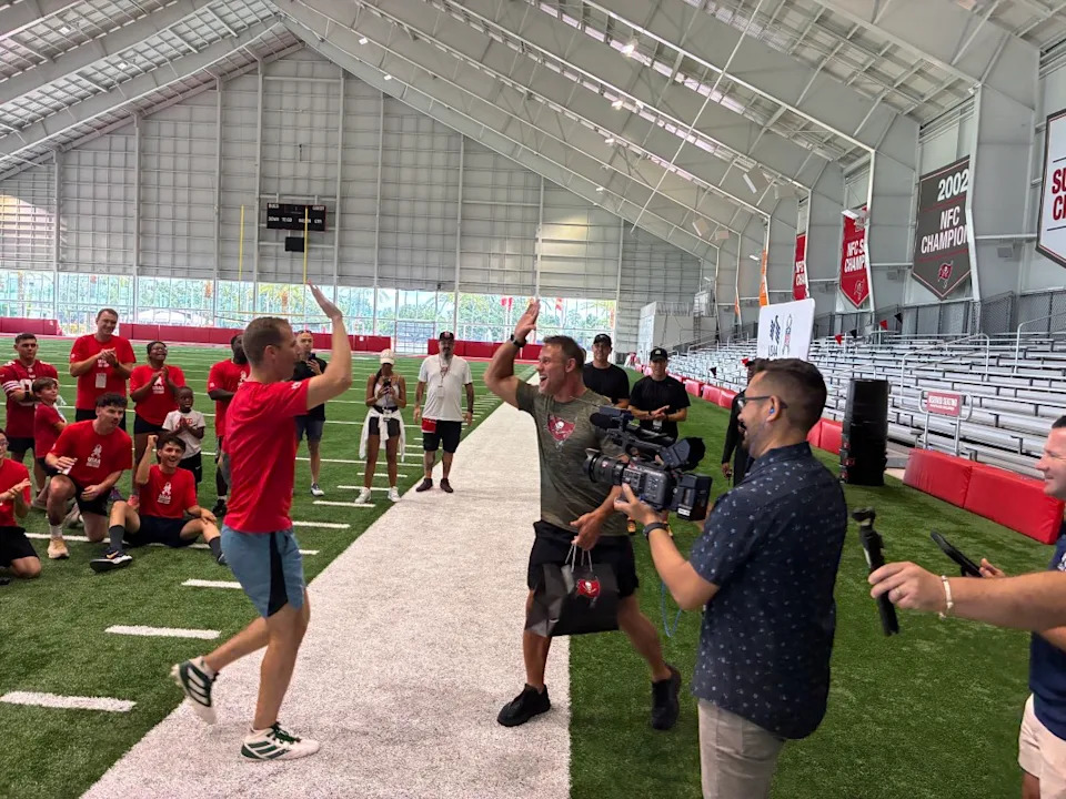 Mike Alstott high-fives a service member after a successful drill.USAA