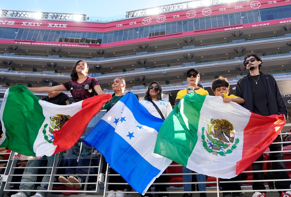 Mexican and Honduran fans with their flags at a Concacaf Gold Cup game.